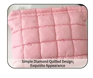Detalle del neceser acolchado rosa con diseño de rombos y textura suave de seda