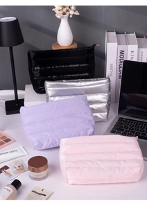 Detailed view of quilted makeup bags in black, silver, purple, and pink colors