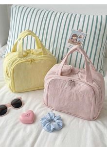 Close-up of quilted cotton makeup bags in pink and yellow with soft fabric texture