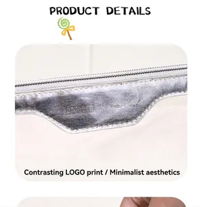 Detail of transparent PVC makeup bag with silver metallic logo tag and grey zipper