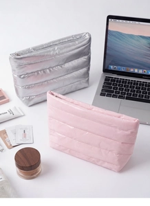 Detailed view of pink and silver quilted cosmetic bags with metallic zippers and nylon texture