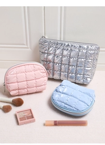 Close-up of quilted makeup bag set in metallic silver, pink and blue glossy fabric