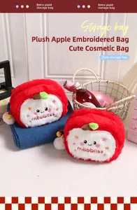 Nahaufnahme der roten Plüsch-Schminktasche in Apfelform mit gesticktem Smile-Gesicht