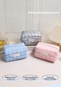 Detail van drie gewatteerde bubble make-up tassen in zilver, roze en blauw