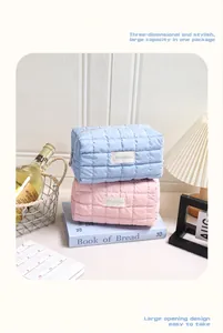 Detailopname van gewatteerde make-uptassen in roze en blauw op een lifestyle-achtergrond