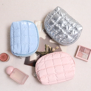 Three-piece quilted makeup bag set in metallic silver, pink, and blue with zipper closure