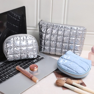 Three-piece quilted metallic makeup bag set in silver and blue with zip closure