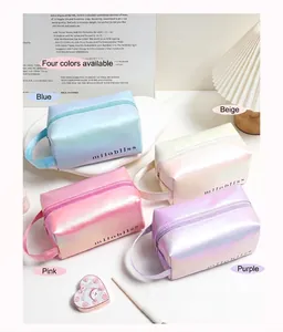 Macro shot of four holographic laser cosmetic bags in pastel blue, beige, pink, and purple