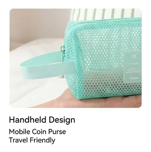 Détail de la trousse de toilette en maille vert menthe avec poignée et étiquette voyage