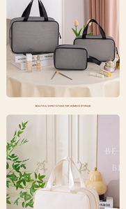 Three-piece set of mesh toiletry bags in grey and cream with portable strap handles