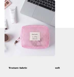 Detailansicht der rosa Netz-Kosmetiktasche mit Perlenreißverschluss und Webetikett