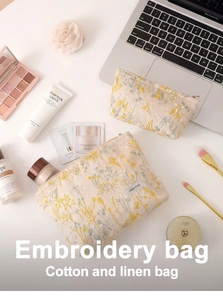 Détail de broderie florale sur trousse de maquillage en coton et lin avec fermeture en métal