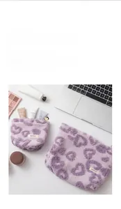 Close-up of purple heart-quilted plush makeup bags with premium golden zipper details