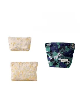 Détails de broderie florale et texture matelassée sur trousses de maquillage en lin