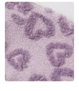 Detail shot of light purple plush fleece fabric featuring soft heart jacquard pattern