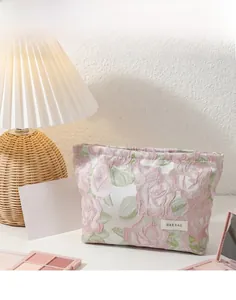 Gros plan d'une trousse à maquillage en lin avec jacquard floral rose et étiquette