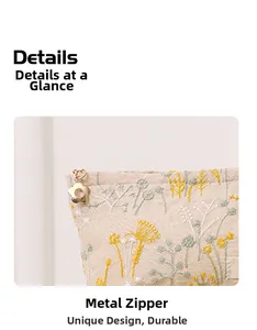 Vue détaillée de la broderie florale et du zip métallique en forme de fleur sur le sac