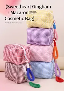 Détails de trousses de maquillage matelassées aux tons macarons avec charms en peluche