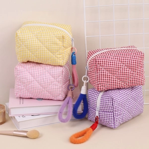 Gros plan de quatre trousses de maquillage matelassées avec fermetures éclair pelucheuses