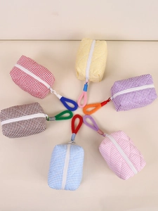 Trousses de maquillage matelassées en sept couleurs disposées en cercle pour le voyage