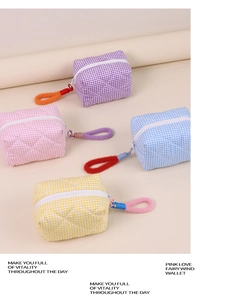 Détail de trousses de toilette matelassées aux tons pastels avec poignées à anneaux