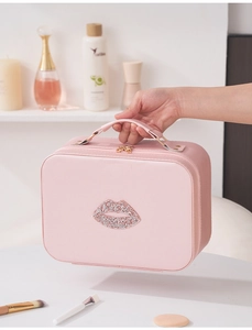 Borsa per trucco rosa in pelle con motivo labbra di cristallo davanti alla toeletta