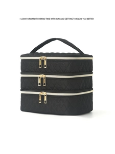 Detailed view of black quilted makeup bag with three layers and gold metal zippers