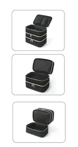 Detailed view of black quilted cosmetic bag with multi-layer compartments and gold zippers