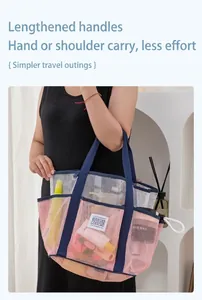 Pink and navy mesh beach tote bag featuring long webbing handles shown on a model