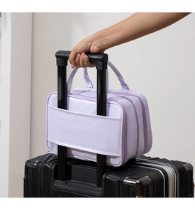 Lavender travel cosmetic bag with back sleeve attached to a suitcase handle