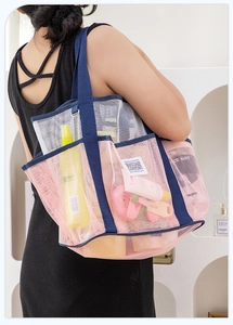 Detailansicht der großen Strandtasche aus Netzstoff mit Seitentaschen und blauen Trägern
