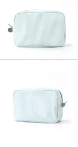 Detailansicht der blau gestreiften Seersucker-Kulturtasche mit silbernem Reißverschluss