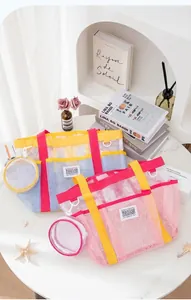 Detail of large mesh beach bag with multiple pockets and small round storage pouch