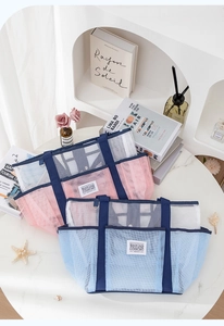 Detail von rosa und blauen Strandtaschen aus Netzstoff mit stabilen Tragegriffen