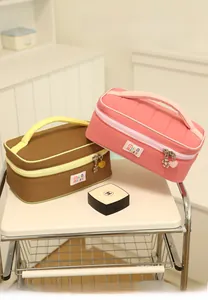 Detailed close-up of macaron color makeup bag with metallic heart charms and fabric label