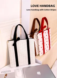 Three quilted heart and polka dot tote bags with ribbon handles on a white display stand