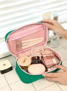 Detail of green canvas makeup bag with pink interior and mesh brush organizer