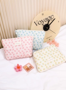 Detailed view of floral embroidered mesh makeup bags in pink, blue, and yellow colors