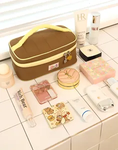 Macro view of large capacity yellow and brown makeup bag with skincare products