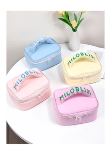 Top view of four colorful quilted makeup bags with embroidered handles on a table
