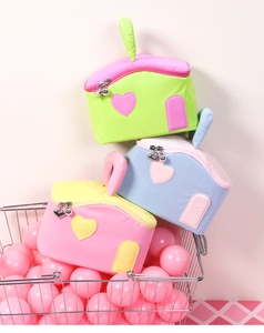 Detailed view of house-shaped makeup bags with heart zippers and macaron colors