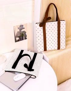 Quilted tote bag set with heart pattern and polka dot laptop sleeve on a table