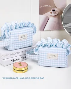 Close-up of light blue checkered makeup bags with elegant ruffle edges and handle