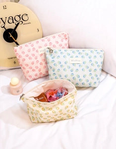 Detailed view of floral mesh makeup bags in pastel colors on a soft white background