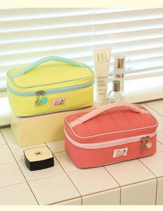 Detailed close-up of quilted nylon cosmetic bags with cute flower and heart charms