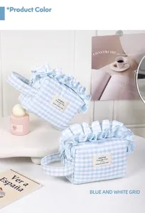 Detailed view of a blue and white checkered cosmetic bag with ruffled edges on a tray