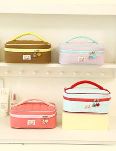 Quilted cosmetic bags in vibrant color-block styles with heart zipper and top handles