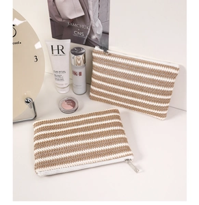 Detail of woven striped cosmetic bags with smooth silver zippers and minimalist texture