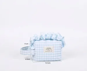 Detailed view of blue gingham ruffle makeup bag with dimensions 13.5 x 6.5 x 11 cm
