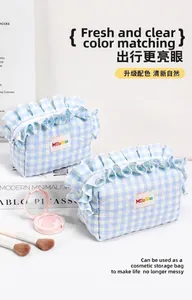 Detalle del neceser de maquillaje a cuadros azul claro con bordes con volantes
